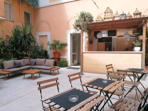 a patio with tables and chairs and a couch at Hotel Lauri in Macerata