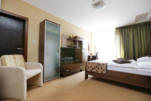 a hotel room with a bed and a chair at City Hotel Nitra with free parking in Nitra