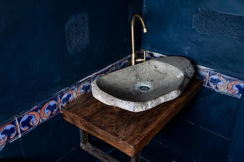 a bathroom with a stone sink on a wooden table at Aldea Sabatinga in Manizales