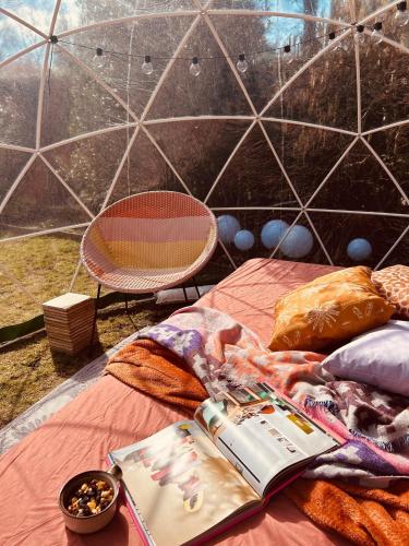 a book laying on a bed with a tent at Tukken op de Maashorst in Schayk
