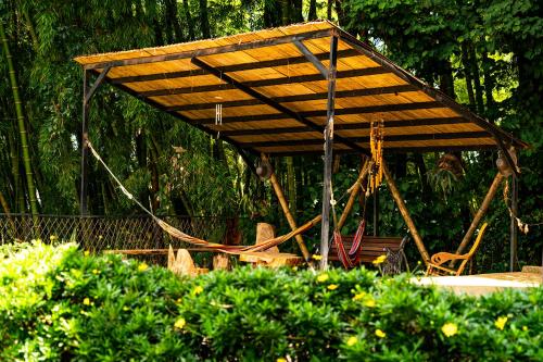 a swing set with a wooden canopy in a garden at Aldea Sabatinga in Manizales