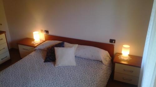 um quarto com uma cama com 2 candeeiros em 2 cómodas em B&B I Pioppi em Chiavenna