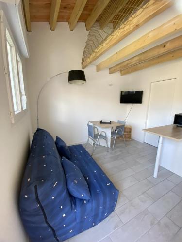 - un salon avec un canapé bleu et une table dans l'établissement logement, à Angliers