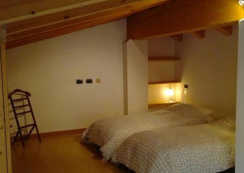 キアヴェンナにあるB&B I Pioppiのベッドルーム1室(ベッド2台付)、壁にははしごが備わります。