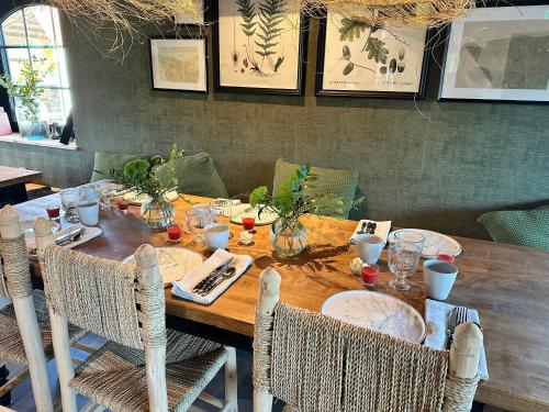 a dining room table with chairs and a wooden tableablish at Boutiquehotell Dahlbogården in Alingsås