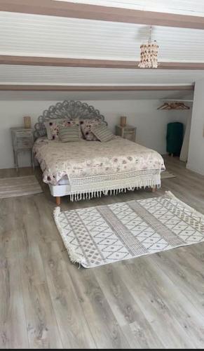 une chambre avec un lit et un parquet dans l'établissement Charmante maison de location à Blauzac (30), à Blauzac