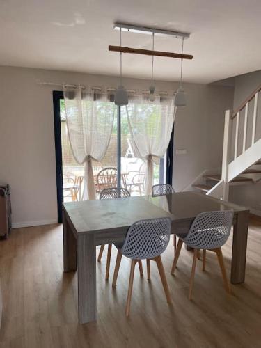 une table de salle à manger et des chaises dans une pièce dans l'établissement Charmante maison de location à Blauzac (30), à Blauzac
