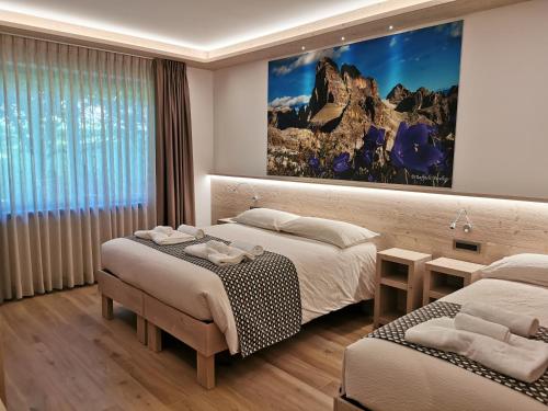 a hotel room with two beds and a large window at Verdi Armonie in Lozzo Cadore