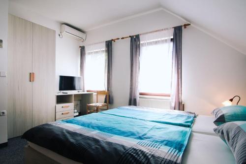 een slaapkamer met 2 bedden en een raam bij Bed and Breakfast Kreft in Ljutomer