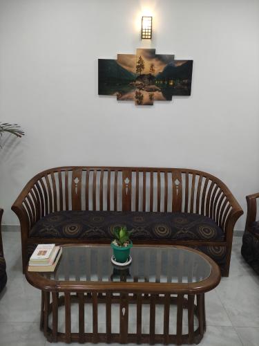 a wooden couch in a living room with a table at Galle Wonvil Apartment in Galle