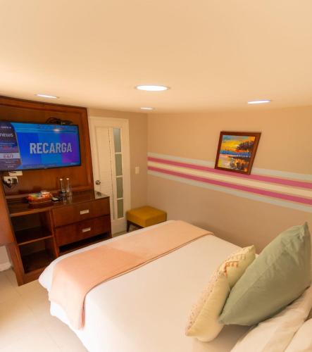 a bedroom with a bed with a television on the wall at Hotel Mansión Barichara in Barichara