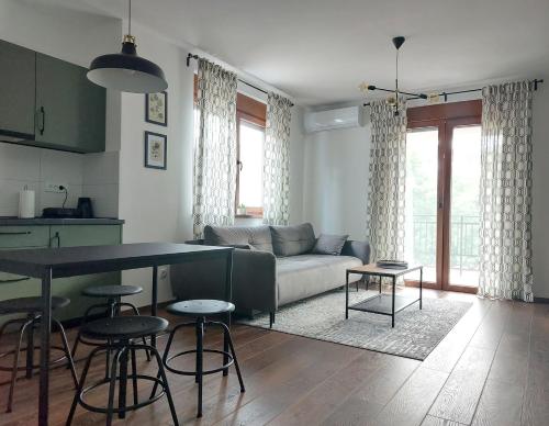 - un salon avec un canapé et une table dans l'établissement Tilia Home, à Vrnjačka Banja