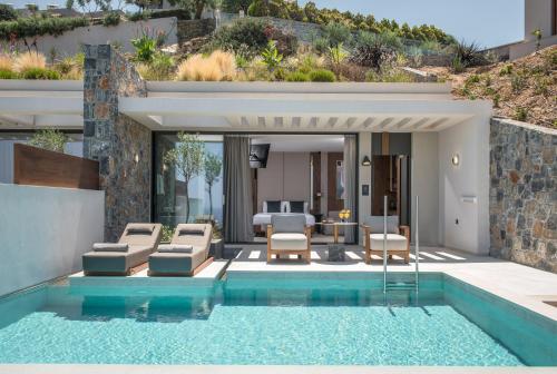 a villa with a swimming pool and a house at Happy Cretan Suites in Agia Pelagia