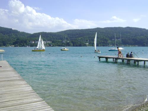 a group of people on a dock with boats in the water at Hotel - Restaurant Soleo in Krumpendorf am Wörthersee