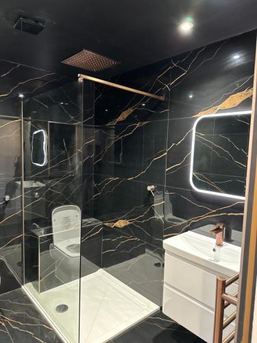 a bathroom with a glass shower and a sink at Casa Amor - Kinky Hotel UK in Southampton