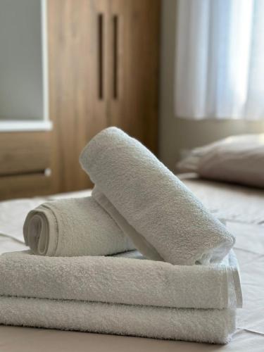 een stapel handdoeken bovenop een bed bij Suit Apartment Golem, Durres in Golem