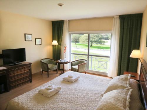 ein Schlafzimmer mit einem Bett mit zwei Handtüchern darauf in der Unterkunft Howard Johnson Hotel & Spa Villa General Belgrano in Villa General Belgrano
