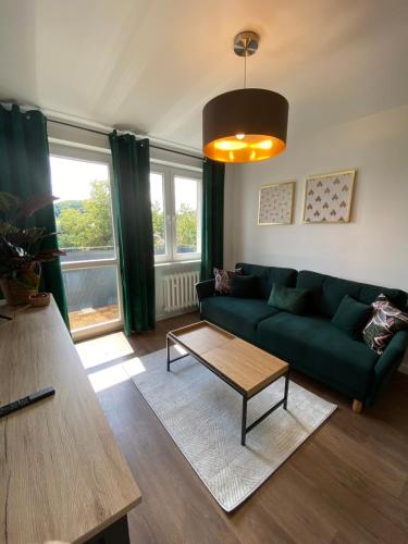 a living room with a green couch and a coffee table at Apartament Słowackiego 29 in Gdańsk