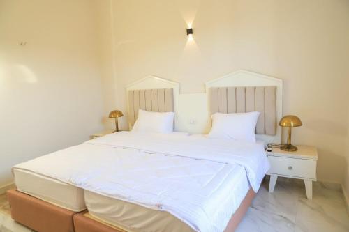 a bedroom with a large white bed with white sheets at Royal Nile Villa - Pool View Apartment 1 in Luxor