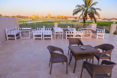 a group of tables and chairs on a patio at Royal Nile Villa - Pool View Apartment 1 in Luxor