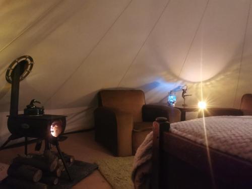 a room with a bed and a stove in a tent at Lainey's Rest in Wisbech