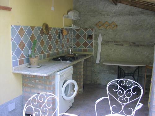 uma cozinha com um fogão, uma mesa e cadeiras em Villino with Garden em Tropea
