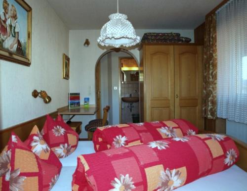 1 dormitorio con 2 camas con colchas rojas y blancas en Gästehaus Kerpf inclusive KönigsCard, en Nesselwang