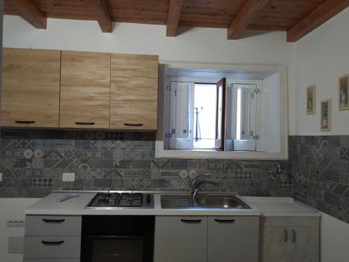 a kitchen with a sink and a stove and a window at Home sweet home in Melilli