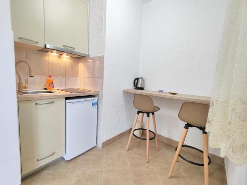 una pequeña cocina con encimera y 2 taburetes en MM Apartments en Budva