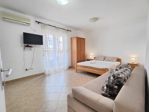a living room with a couch and a bed at MM Apartments in Budva