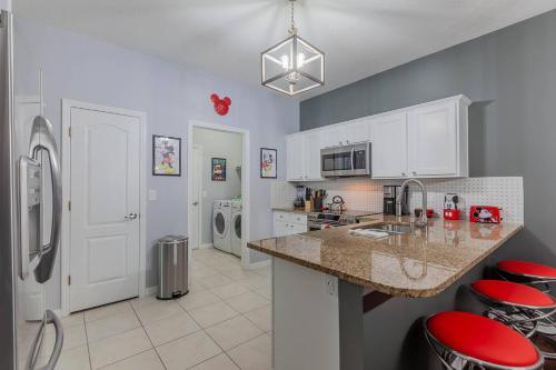 a kitchen with white cabinets and a counter with red stools at Thematic House with Private pool and Game Room in Loughman