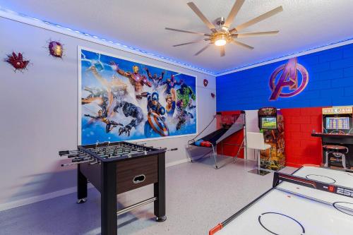 a room with a marvel mural and a game table at Thematic House with Private pool and Game Room in Loughman