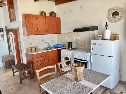 a kitchen with a table and a white refrigerator at Casa Amalia in Paradeísion