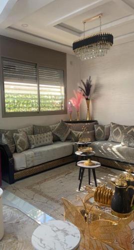 uma sala de estar com sofás e um lustre em planets house em Deroua