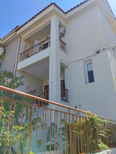 Biały dom z balkonem i ogrodzeniem w obiekcie Argostoli Elia's Maisonette w mieście Argostoli