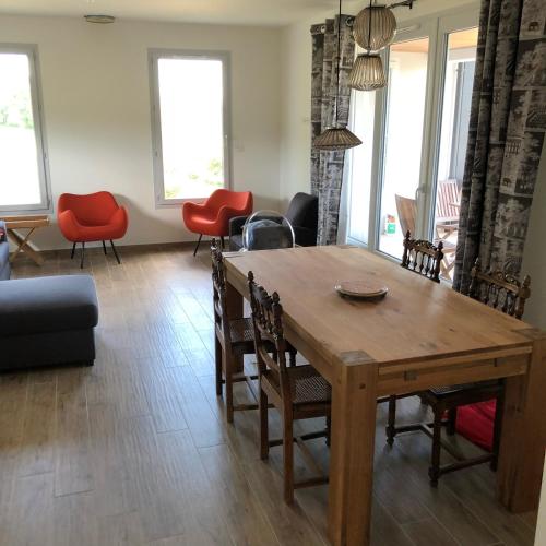 un salon avec une table et des chaises en bois dans l'établissement Maison en pleine nature avec spa, à Vezels-Roussy