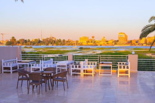 a patio with tables and chairs and a view of the city at Royal Nile Villas - Pool View Apartment 2 in Luxor