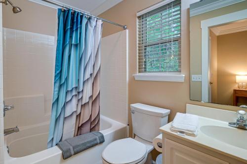 a bathroom with a toilet and a tub and a sink at High-End Pawleys Island Condo with Porch and Pools! in Pawleys Island