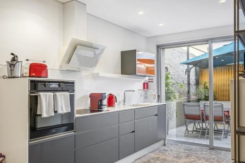a kitchen with a stove top oven next to a patio at Casa do Batente - By WeHost in Funchal