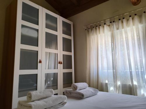 a bedroom with towels on a bed with a window at La casita de Ra in Castillo de Bayuela
