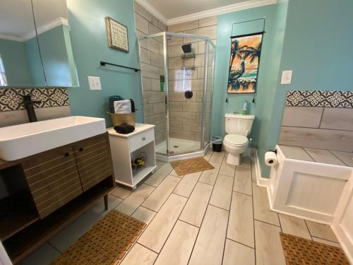 a bathroom with a shower and a sink and a toilet at Pelican Nest-Heated Pool Jacuzzi Tub Pvt Balcony in Pensacola