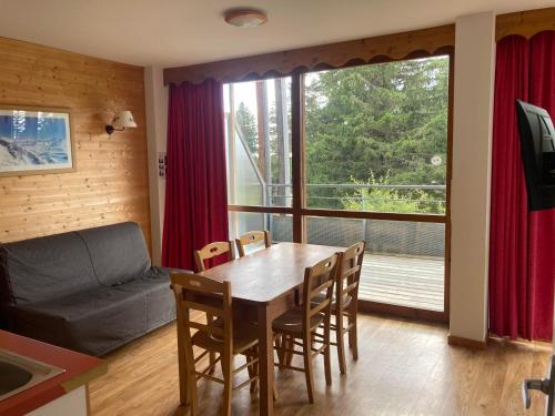 un salon avec une table, des chaises et un canapé dans l'établissement Appartement pied des pistes, terrasse wifi et parking, à Chamrousse