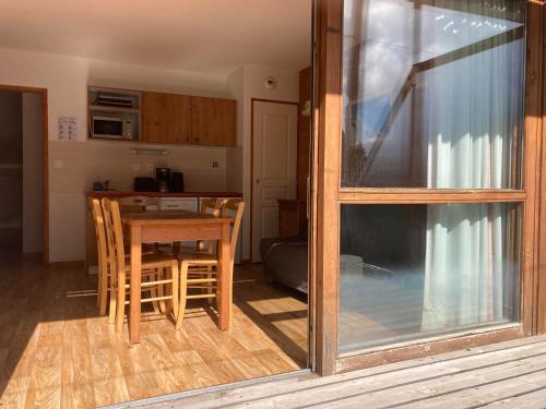 une cuisine et une salle à manger avec une table et des chaises dans l'établissement Appartement pied des pistes, terrasse wifi et parking, à Chamrousse