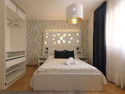 ein Schlafzimmer mit einem weißen Bett und einem Kronleuchter in der Unterkunft Casa Vazquez in Costa Del Silencio