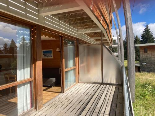 une terrasse couverte avec des portes coulissantes en verre dans l'établissement Appartement pied des pistes, terrasse wifi et parking, à Chamrousse