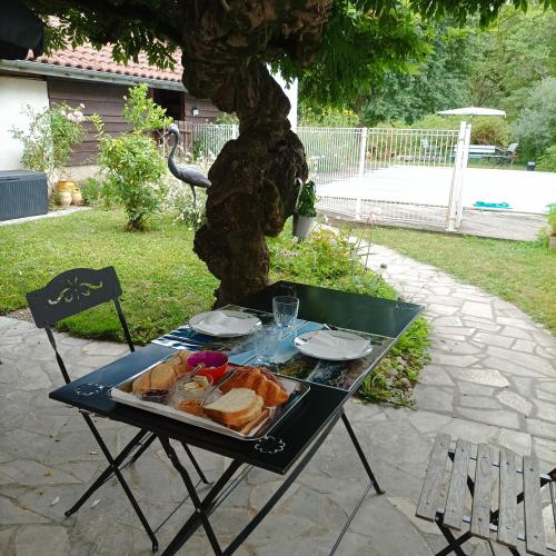 een picknicktafel met een dienblad met eten erop bij Chambres d'hôtes Villa Lortin in Pouillon