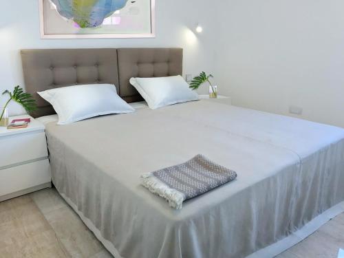 1 cama blanca grande con 2 almohadas en Modern Apartment for 4 persons, Sea view, near the beach, Parking, en Supetar