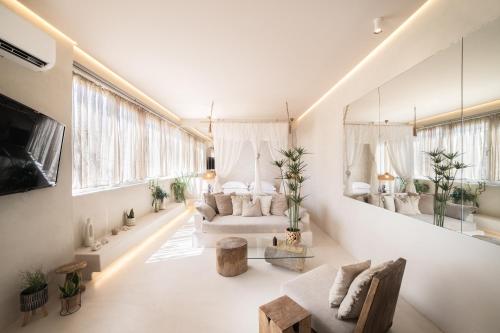 a living room with white furniture and a large window at Gèa Athenian Suites in Athens