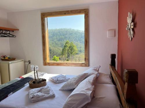 una camera con un letto e una finestra di Chales Sitio dos Ventos a Lavras Novas
