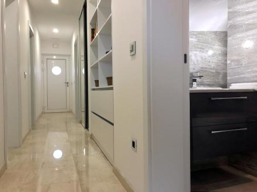 pasillo con cocina con paredes blancas y barra en Modern Apartment for 4 persons, Sea view, near the beach, Parking, en Supetar